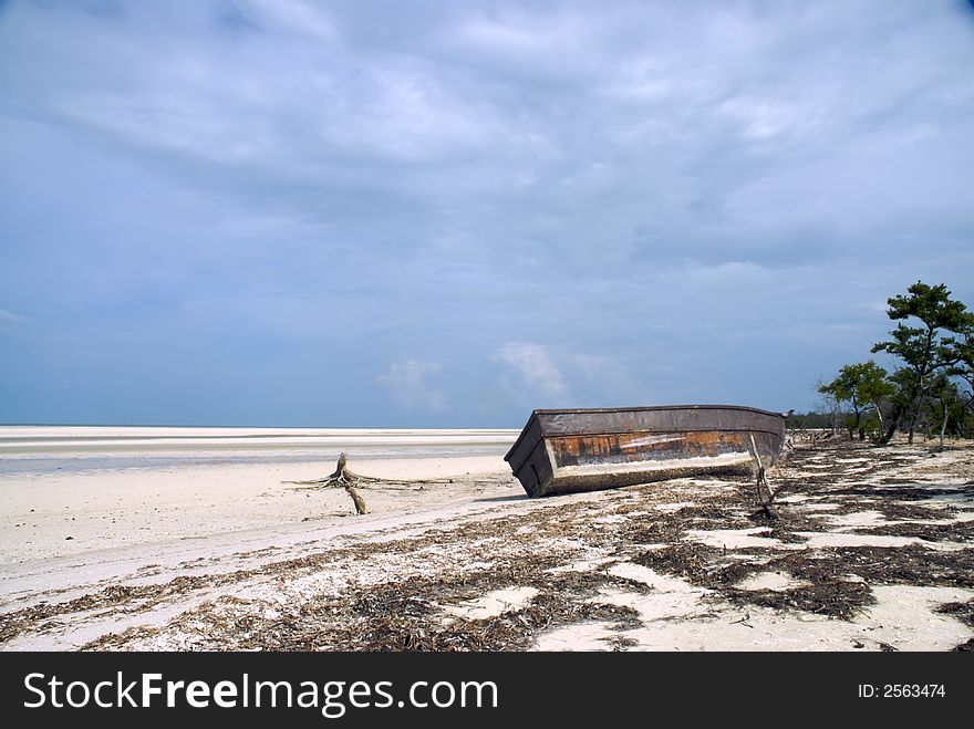 A tropical beach with a boat pulled up on it. A tropical beach with a boat pulled up on it