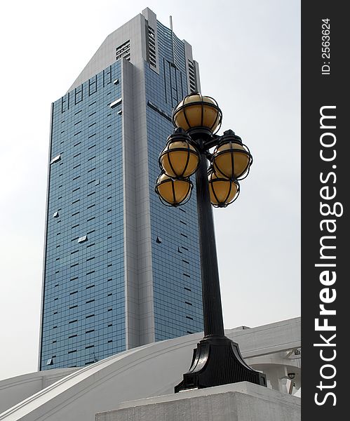 A modern business building is contrasted against a victorian era lamppost. A modern business building is contrasted against a victorian era lamppost