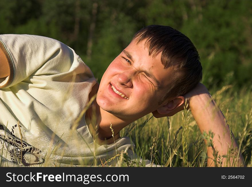 Young man; crossed; smiling; sunlight