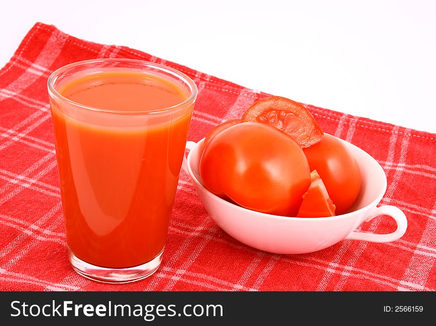 Close-up of a few tomatoes and a glass of juice. Close-up of a few tomatoes and a glass of juice.