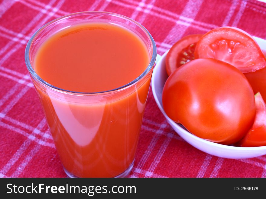 Close-up of a few tomatoes and a glass of juice. Close-up of a few tomatoes and a glass of juice.