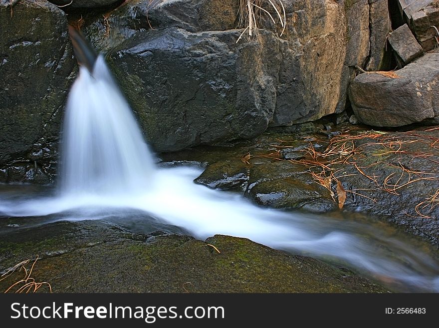 A small waterfall following a path. A small waterfall following a path