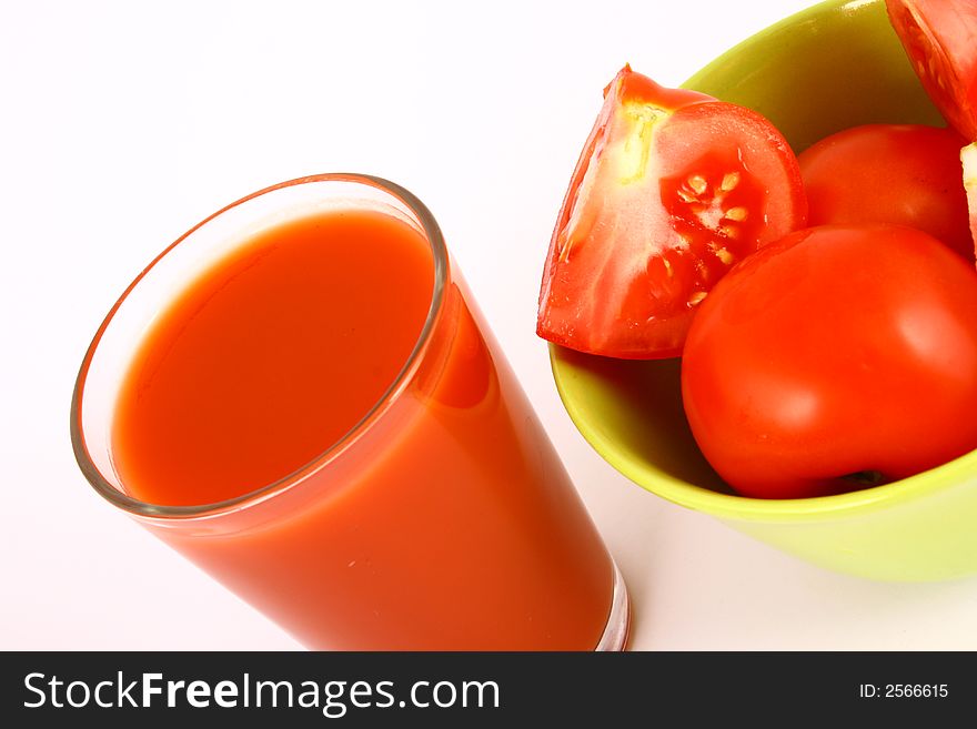 Close-up of a few tomatoes and a glass of juice. Close-up of a few tomatoes and a glass of juice.