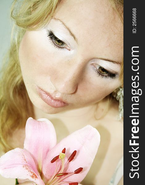 beauty portrait of a young fresh woman with a lily flower