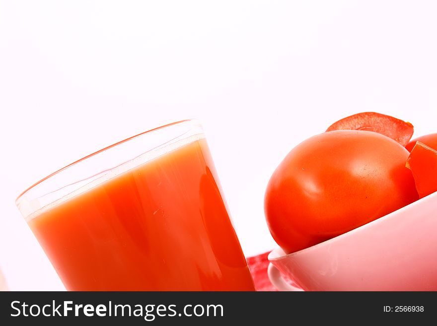 Close-up of a few tomatoes and a glass of juice. Close-up of a few tomatoes and a glass of juice.