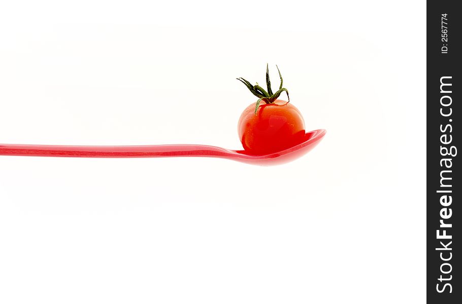 Cherry tomato on a red plastic spoon