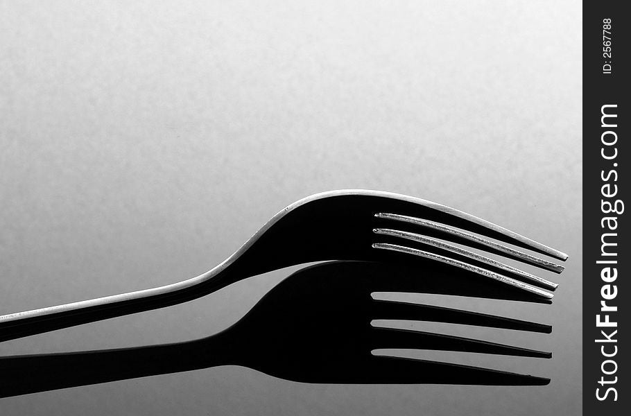 Fork with shadow on a glass table