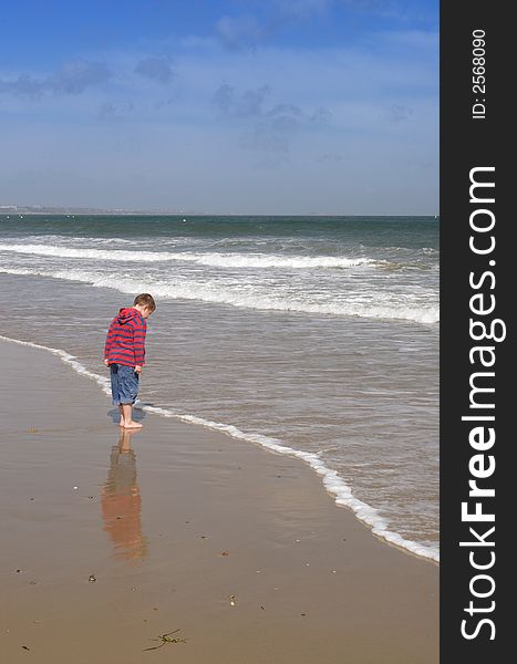 Little boy on a beach and reflection