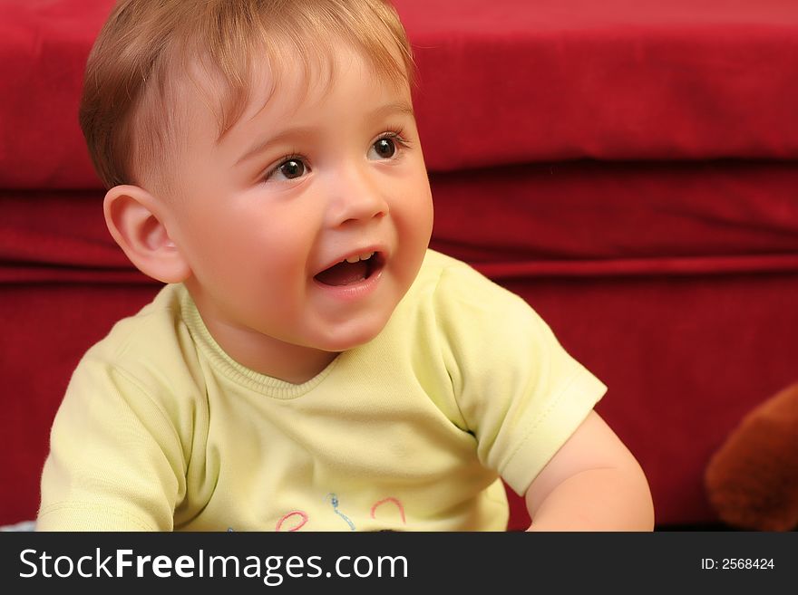 Expressive little blond baby boy gesticulate while playing with toys