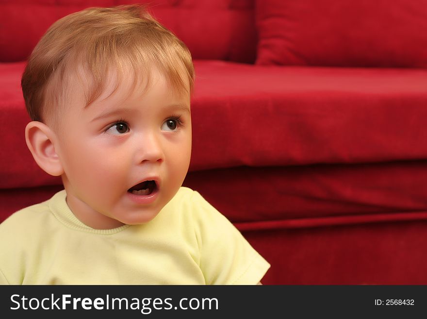 Expressive little blond baby boy gesticulate while playing with toys