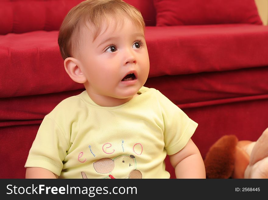 Expressive little blond baby boy gesticulate while playing with toys