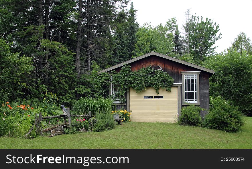 Closeup of a charming wood garage with flower garden. Closeup of a charming wood garage with flower garden