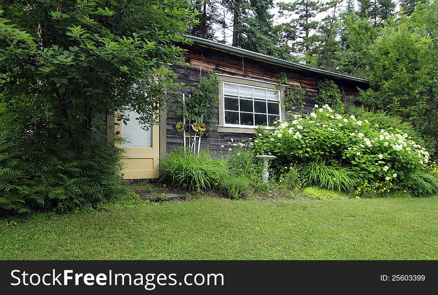 Closeup of a charming wood house with flower garden. Closeup of a charming wood house with flower garden