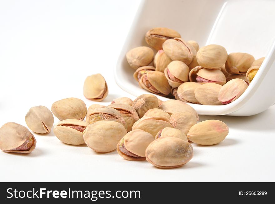 Bowl of Pistachio nuts on isolated white