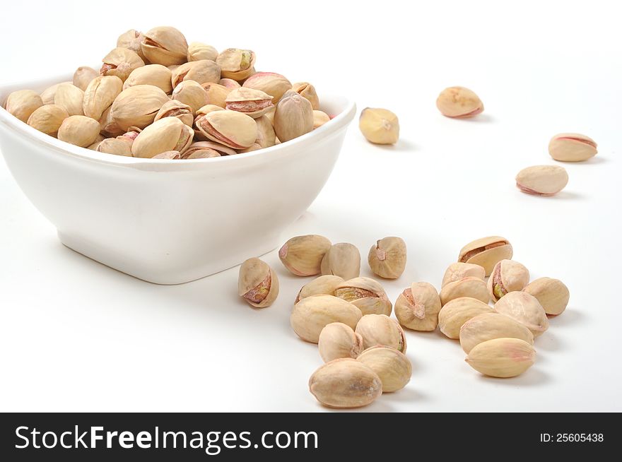 Bowl of Pistachio nuts on isolated white