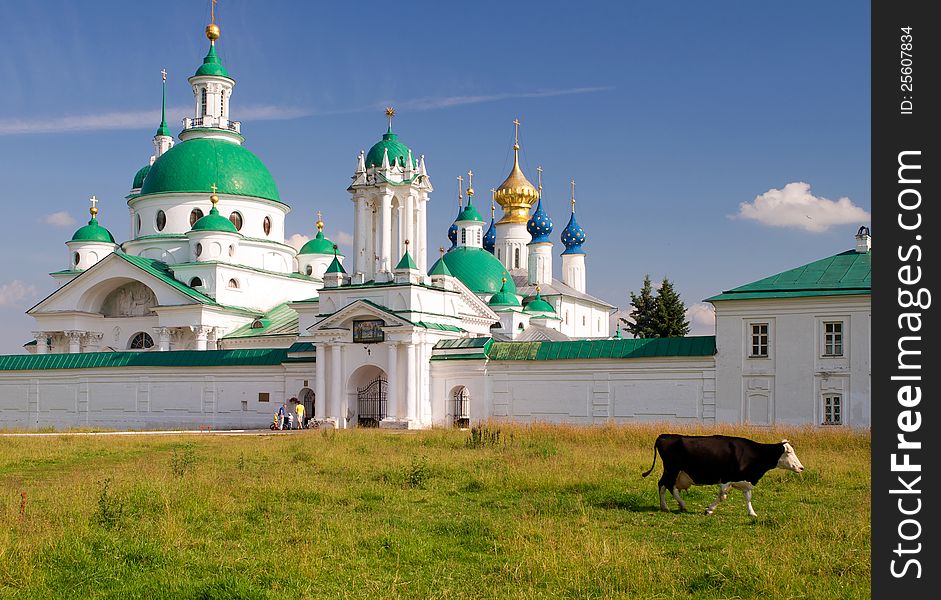 Cow goes past the Spaso-Yakovlevsky Monastery in Rostov the Great, Russia. The ancient town of Rostov the Great is a tourist center of the Golden Ring of Russia. Cow goes past the Spaso-Yakovlevsky Monastery in Rostov the Great, Russia. The ancient town of Rostov the Great is a tourist center of the Golden Ring of Russia.