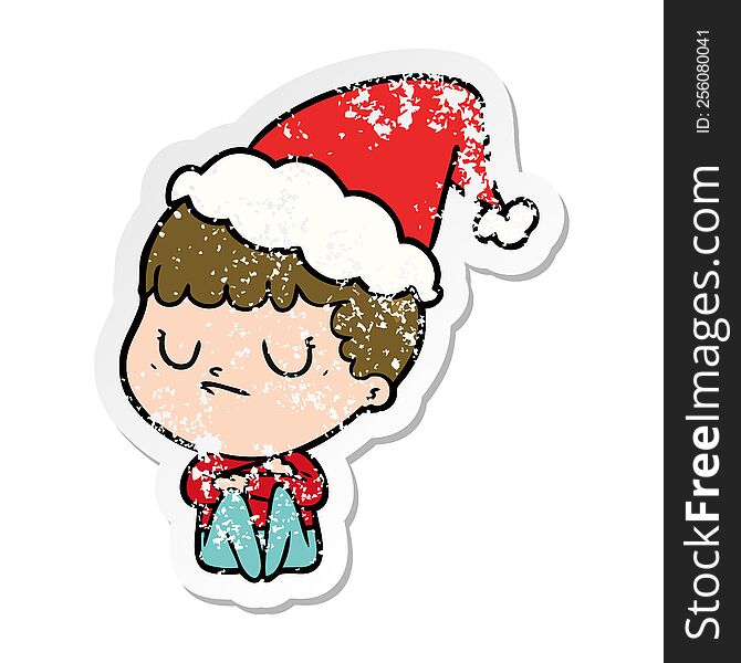 hand drawn distressed sticker cartoon of a grumpy boy wearing santa hat