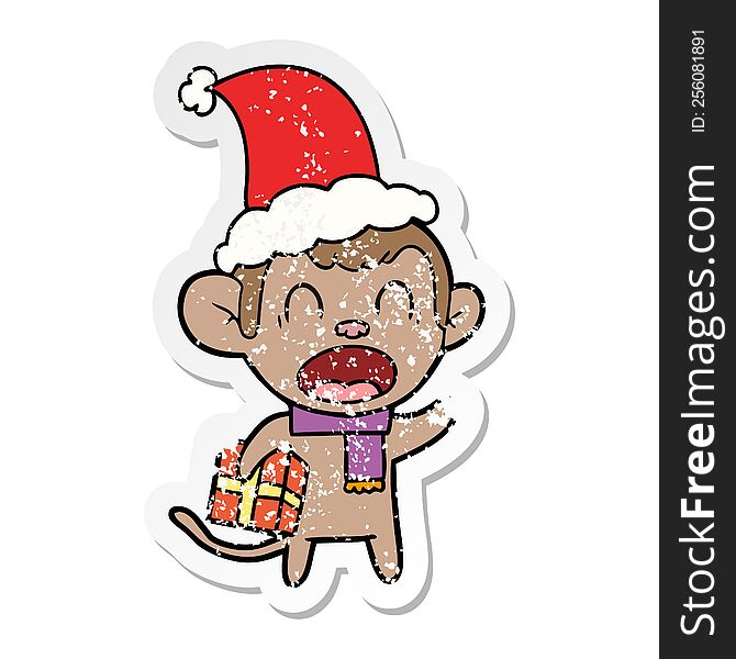 shouting hand drawn distressed sticker cartoon of a monkey carrying christmas gift wearing santa hat
