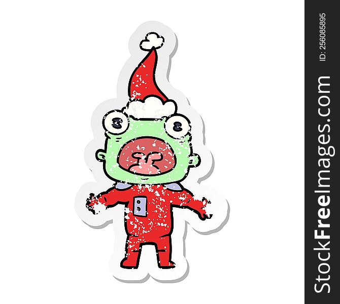 hand drawn distressed sticker cartoon of a weird alien communicating wearing santa hat