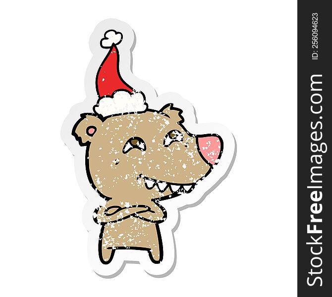 hand drawn distressed sticker cartoon of a bear showing teeth wearing santa hat