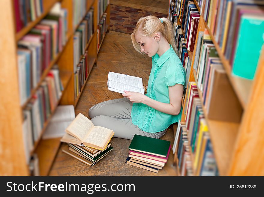 Young student girl selecting book in library. Young student girl selecting book in library