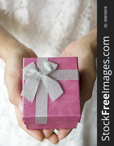 Woman hands hold pink gift box for giving. Woman hands hold pink gift box for giving