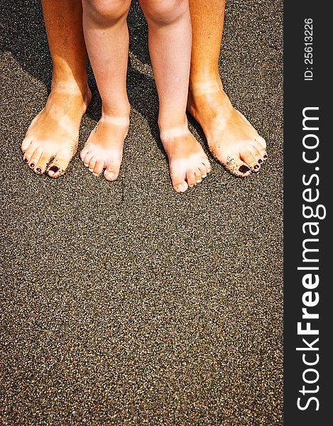 The beautiful female and children's legs made on a beach. The beautiful female and children's legs made on a beach