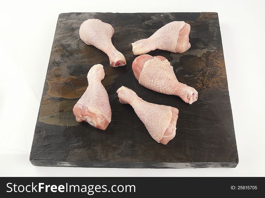 Fresh uncooked chicken legs against grey