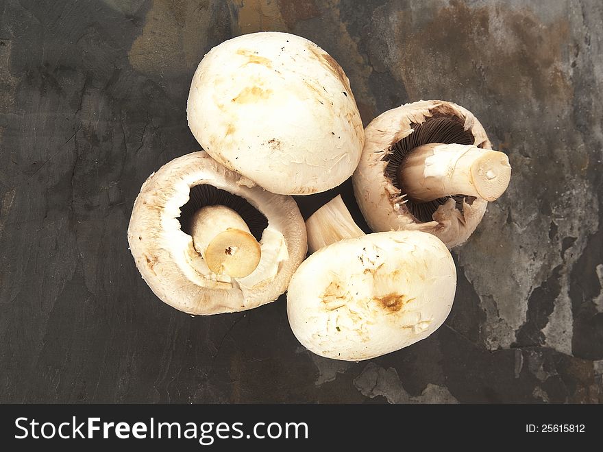 Fresh organic mushrooms against grey slate