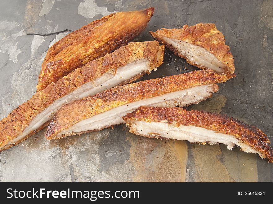 Crispy pork slices against grey