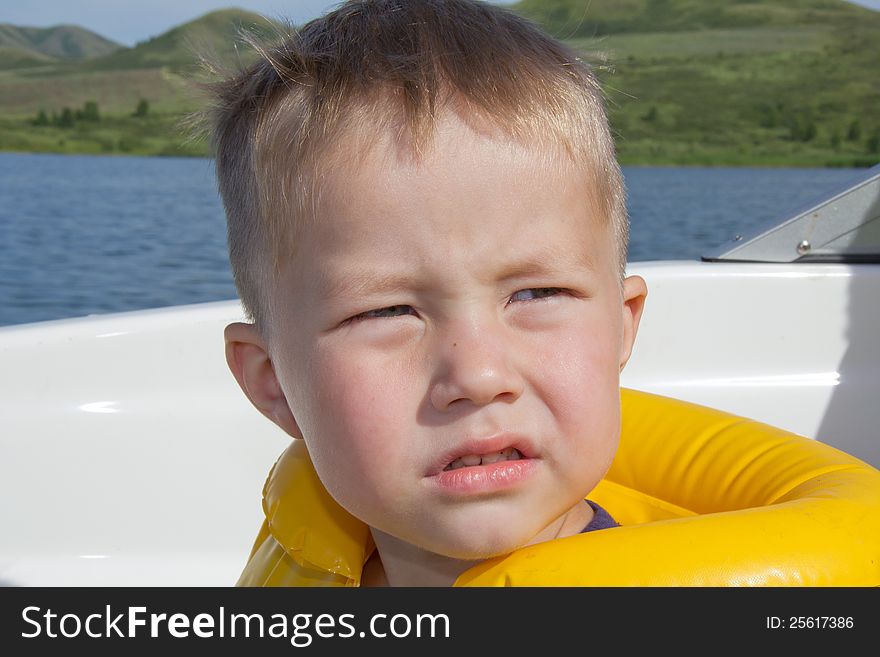 Little boy sitting in the bow of a boat with there life jackets having fun. Little boy sitting in the bow of a boat with there life jackets having fun