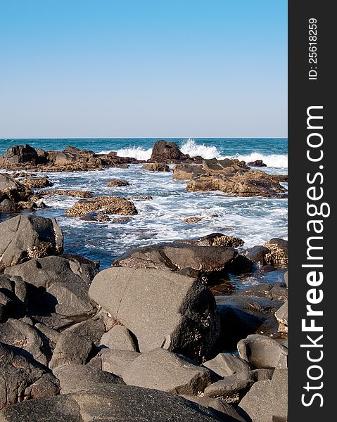 Waves beak and surf swirls around rocks along the rugged coast of Ballito, KwaZulu-Natal North Coast, South Africa. Waves beak and surf swirls around rocks along the rugged coast of Ballito, KwaZulu-Natal North Coast, South Africa.
