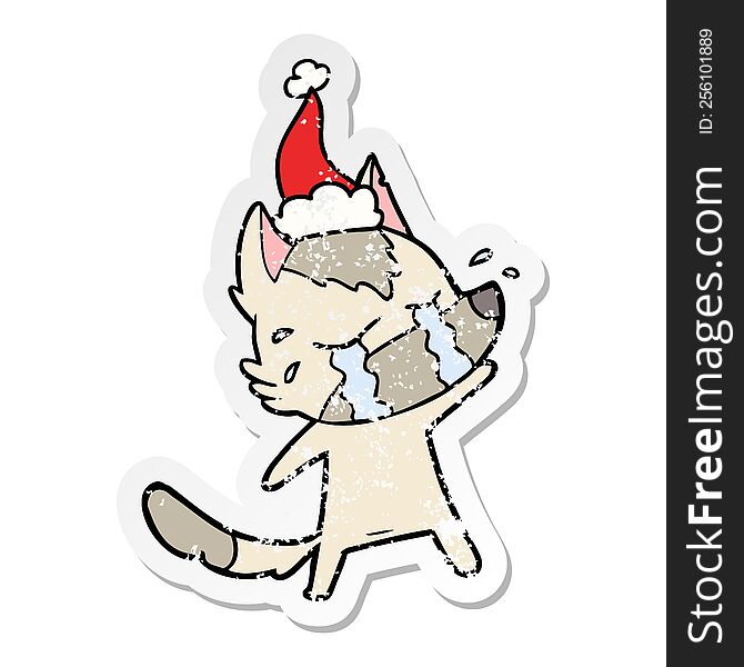 Distressed Sticker Cartoon Of A Crying Wolf Wearing Santa Hat