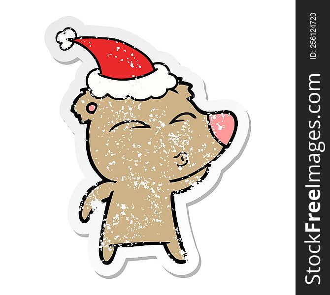 Distressed Sticker Cartoon Of A Whistling Bear Wearing Santa Hat