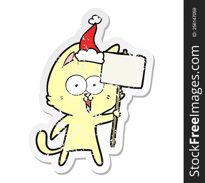 funny hand drawn distressed sticker cartoon of a cat with sign wearing santa hat