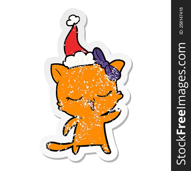 hand drawn distressed sticker cartoon of a cat with bow on head wearing santa hat