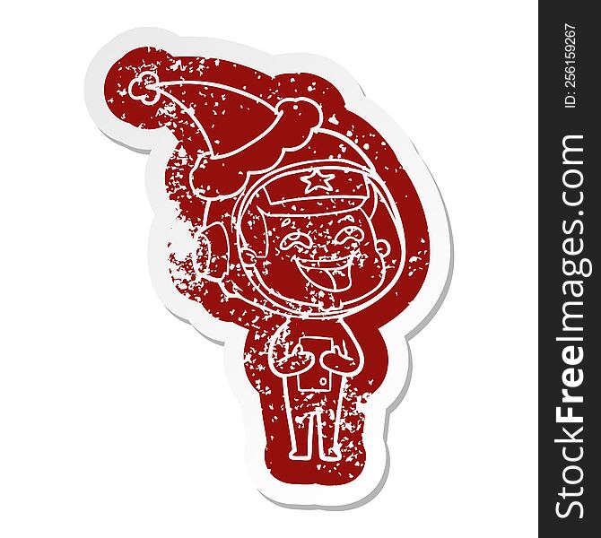 Cartoon Distressed Sticker Of A Laughing Astronaut Wearing Santa Hat
