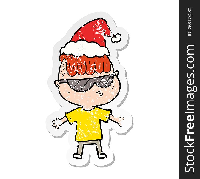 distressed sticker cartoon of a boy wearing sunglasses wearing santa hat