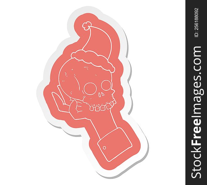 Cartoon  Sticker Of A Hand Holding Skull Wearing Santa Hat