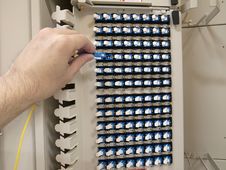 Optical Fiber Patch Panel With A Human Hand Stock Image