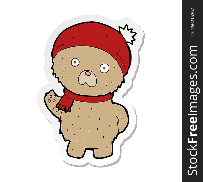 sticker of a cartoon teddy bear in winter hat and scarf