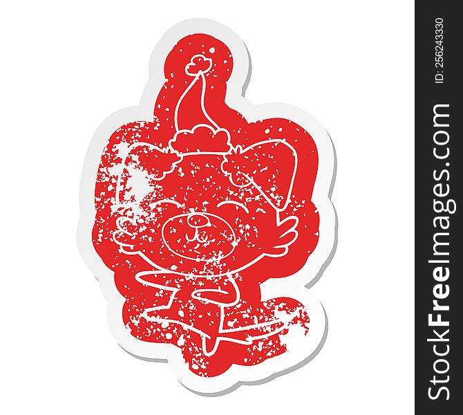 quirky cartoon distressed sticker of a dog kicking wearing santa hat