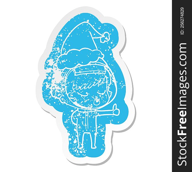 Cartoon Distressed Sticker Of A Pretty Astronaut Girl Giving Thumbs Up Wearing Santa Hat