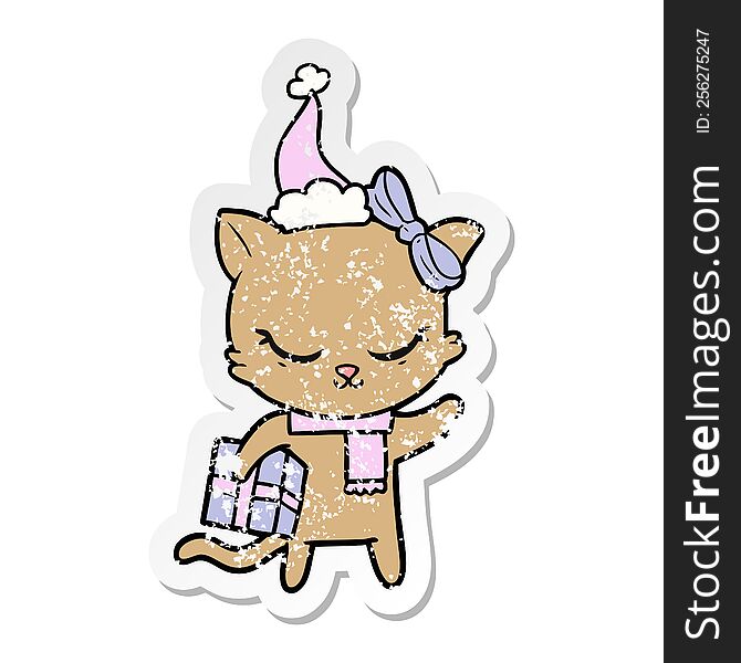 cute hand drawn distressed sticker cartoon of a cat with present wearing santa hat