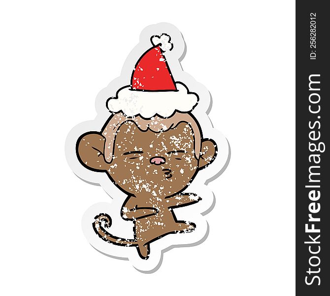 Distressed Sticker Cartoon Of A Suspicious Monkey Wearing Santa Hat