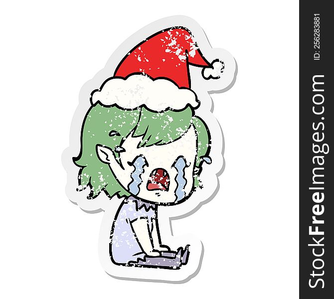 hand drawn distressed sticker cartoon of a crying vampire girl wearing santa hat