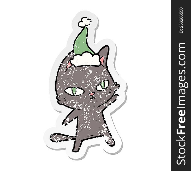 hand drawn distressed sticker cartoon of a cat staring wearing santa hat