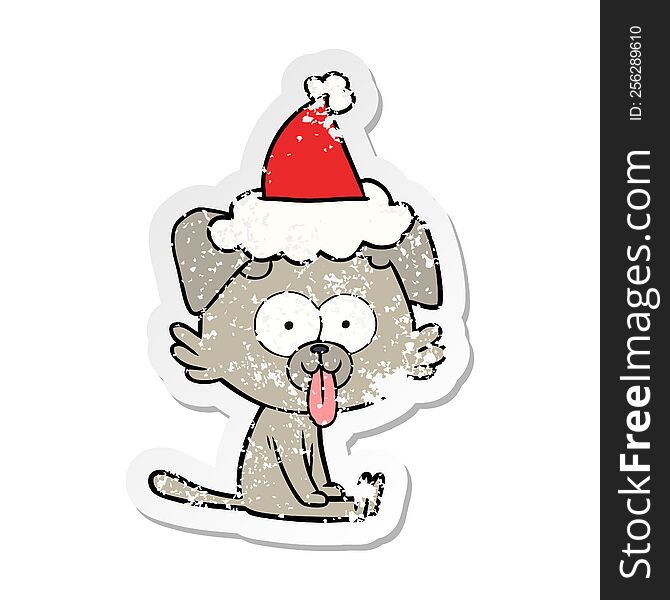 hand drawn distressed sticker cartoon of a sitting dog with tongue sticking out wearing santa hat