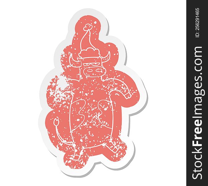 quirky cartoon distressed sticker of a bull wearing santa hat