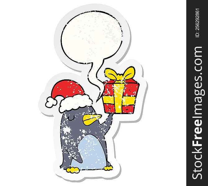 cartoon penguin with christmas present with speech bubble distressed distressed old sticker. cartoon penguin with christmas present with speech bubble distressed distressed old sticker